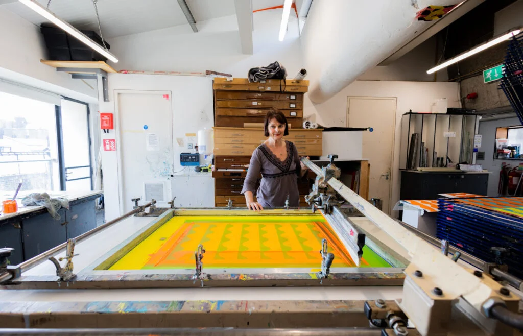 Mary O'Connor in her studio at the screen-printing press